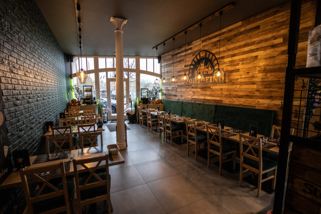 Das Bild zeigt das Restaurant Portofino in Lübeck. Zu sehen sind stilvolle Sitzgelegenheiten, eine gemütliche Atmosphäre mit warmem Licht und ein geschmackvoll eingerichtetes Interieur, das eine einladende Essensumgebung schafft.